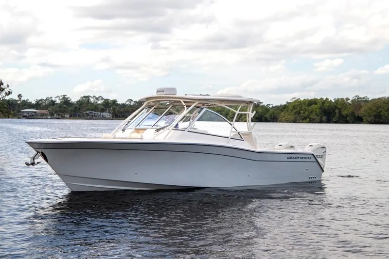 Slide: The Image of 2024 Grady-White Freedom 335 boat on calm water under cloudy sky. - 7