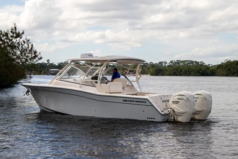 Slide: The Image of 2024 Grady-White Freedom 335 boat cruising on a calm lake under cloudy skies. - 9