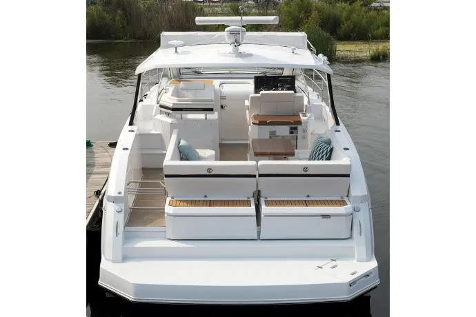 Slide: The Image of 2021 Cruisers Yachts 390 Express Coupe on serene lake with red umbrellas. - 6