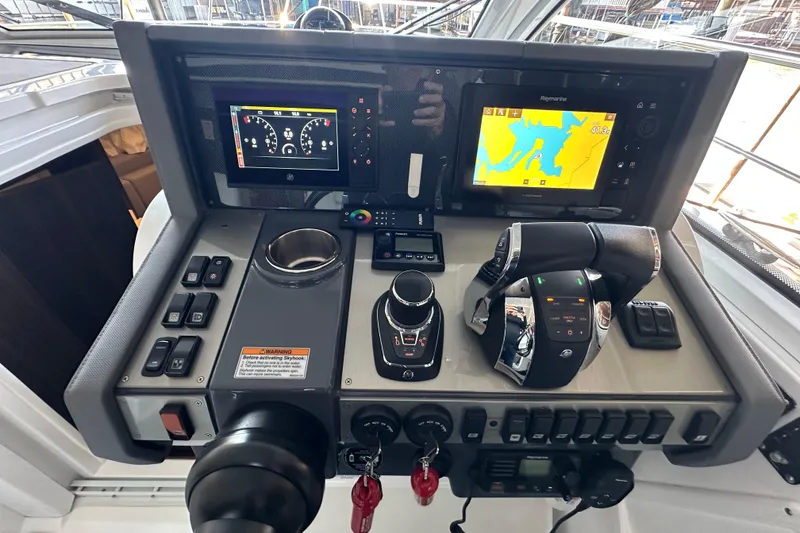 Slide: The Image of Control panel of 2021 Cruisers Yachts 390 Express Coupe with navigation and throttle systems. - 16