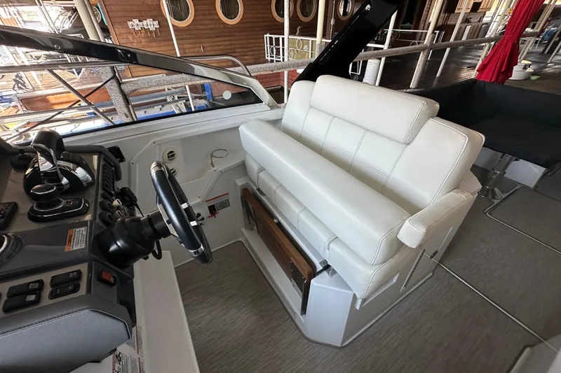 Slide: The Image of 2021 Cruisers Yachts 390 Express Coupe helm with white seating and control panel. - 18