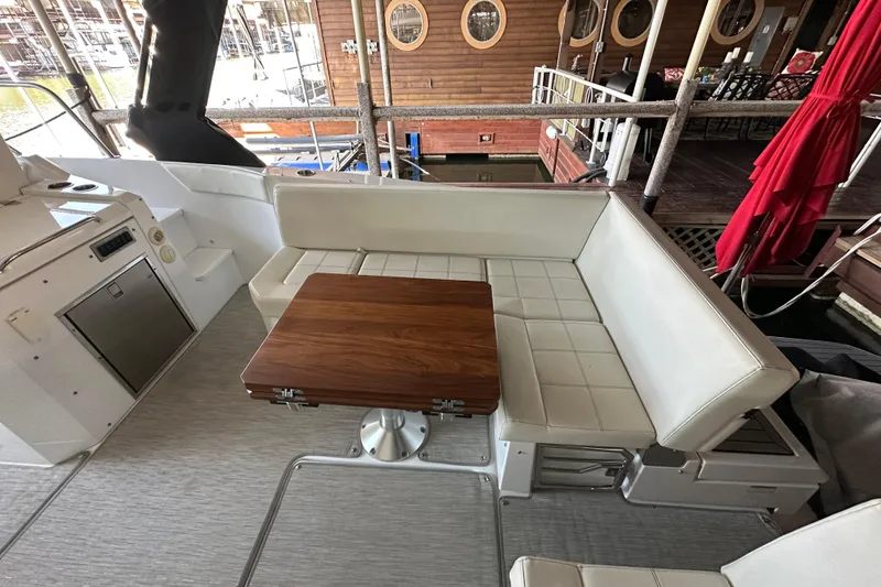 Slide: The Image of 2021 Cruisers Yachts 390 Express Coupe interior with white seating and wooden table. - 22
