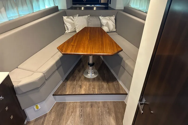 Slide: The Image of 2021 Cruisers Yachts 390 Express Coupe interior with elegant dining area and wooden table. - 28