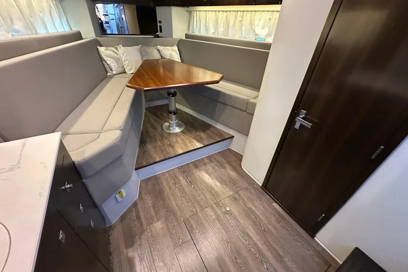 Slide: The Image of 2021 Cruisers Yachts 390 Express Coupe interior with modern seating and wooden table. - 36