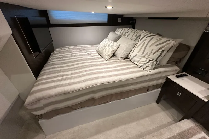 Slide: The Image of Luxurious bedroom interior of 2021 Cruisers Yachts 390 Express Coupe with striped bedding. - 45
