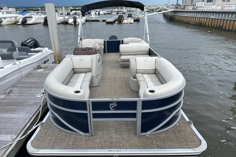 Slide: The Image of 2023 Cypress Cay Seabreeze 232 pontoon boat docked, featuring spacious seating and elegant design. - 2