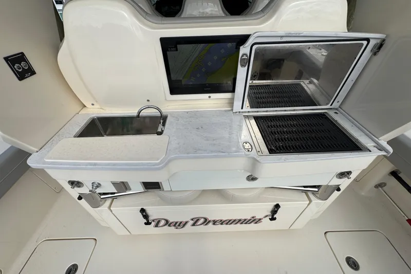 Slide: The Image of 2024 Scout 425 LXF boat kitchen with sink, grill, and storage labeled "Day Dreamin'." - 19