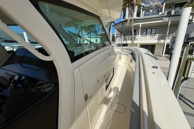 Slide: The Image of 2024 Scout 425 LXF boat docked near waterfront homes. - 31