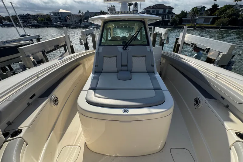 Slide: The Image of 2024 Scout 425 LXF boat interior with seating, docked by waterfront homes. - 37