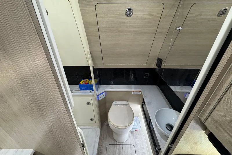 Slide: The Image of 2024 Scout 425 LXF boat bathroom with modern fixtures and wood paneling. - 46