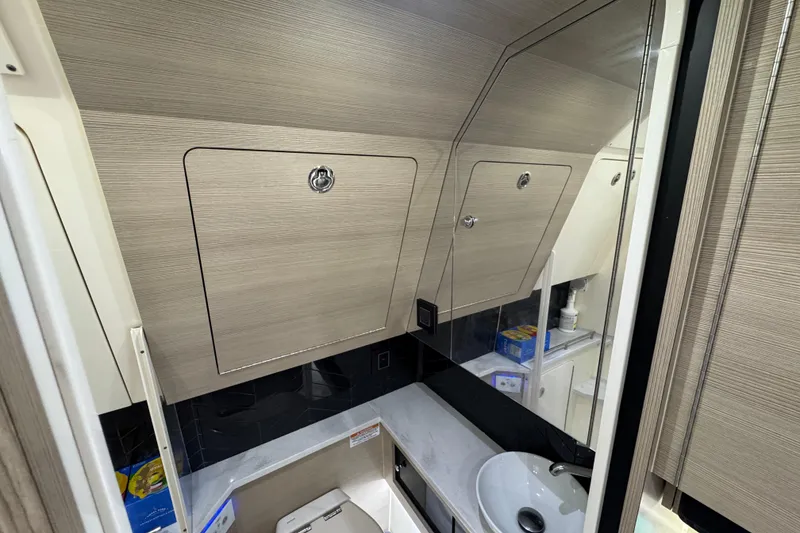 Slide: The Image of 2024 Scout 425 LXF boat interior bathroom with modern fixtures and storage cabinets. - 47
