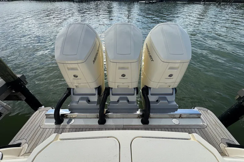 Slide: The Image of Triple Mercury Verado engines on 2024 Scout 425 LXF boat, docked by the water. - 50