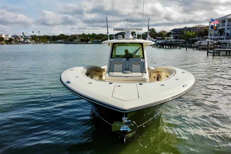 Slide: The Image of 2024 Scout 425 LXF boat on calm water, front view with clear sky. - 8