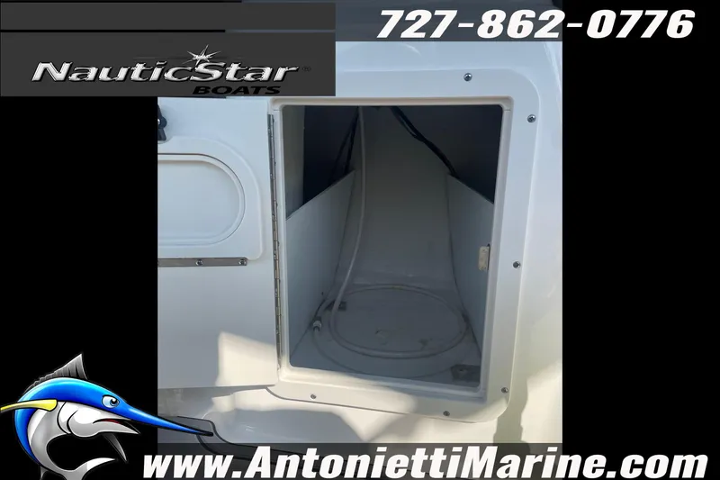 Slide: The Image of 2023 NauticStar 243 DC boat storage compartment with contact details and logo. - 14