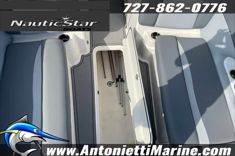 Slide: The Image of 2023 NauticStar 243 DC boat interior with storage compartment, gray seating, and contact details. - 16