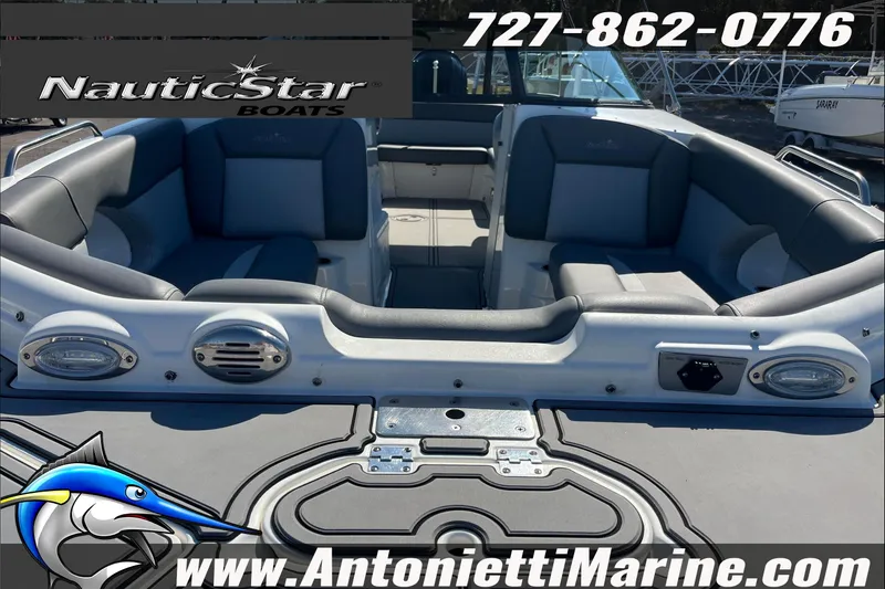 Slide: The Image of 2023 NauticStar 243 DC boat interior with seating, contact info, and logo. - 7