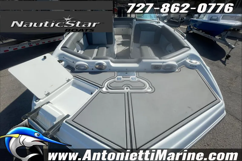 Slide: The Image of 2023 NauticStar 243 DC boat with open deck, gray seating, and storage compartments. - 9