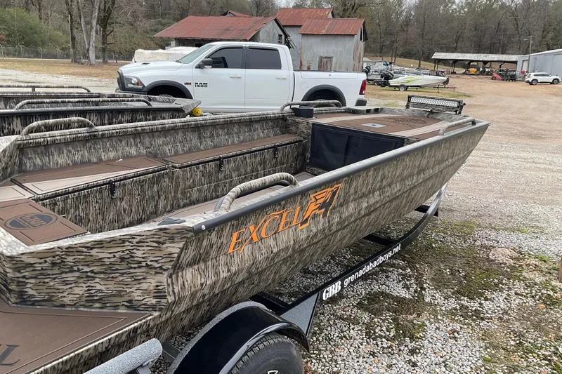 Slide: The Image of 2026 Excel Boats 1751 VIPER F4 in camo design, parked outdoors near rustic buildings. - 3