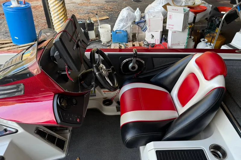 Slide: The Image of 2014 Ranger Z520 Comanche boat cockpit with red and white seat, steering wheel, and control panel. - 14