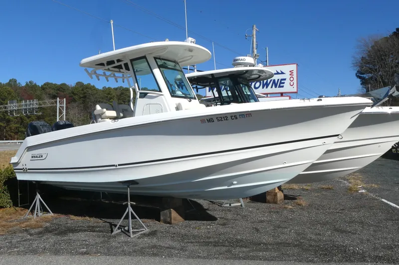 The Image of 2017 Boston Whaler 250 Outrage boat displayed on stands outdoors. - 0