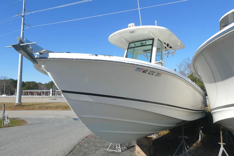 Slide: The Image of 2017 Boston Whaler 250 Outrage boat on display, parked on stands, clear blue sky. - 2