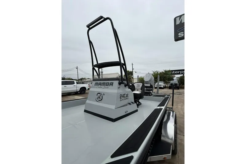 Slide: The Image of 2026 Mamba 24 Cat Elite boat with elevated platform, parked in a dealership lot. - 11