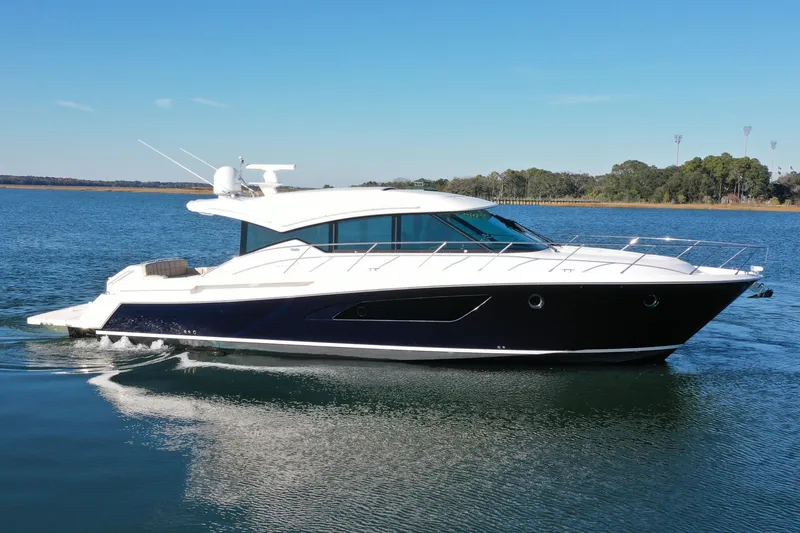 The Image of 2016 Tiara Yachts 50 Coupe cruising on a calm lake under a clear blue sky. - 0