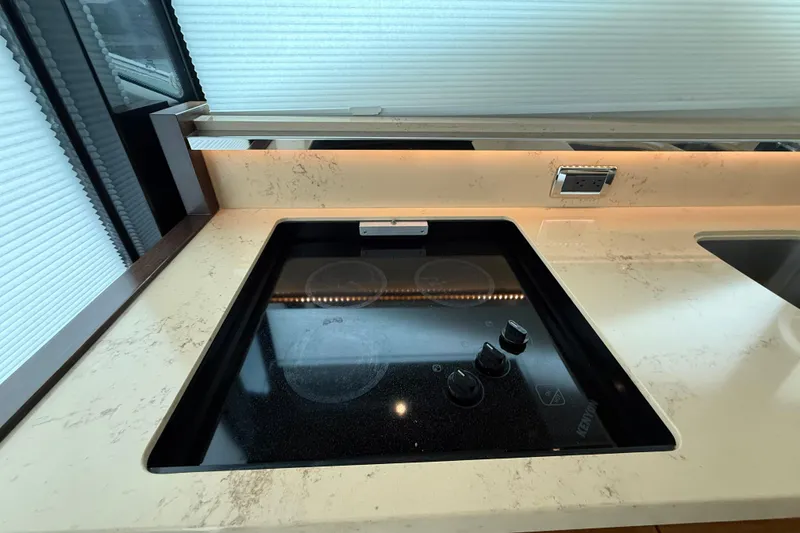 Slide: The Image of Modern kitchen area in 2016 Tiara Yachts 50 Coupe with sleek stovetop and marble countertop. - 17
