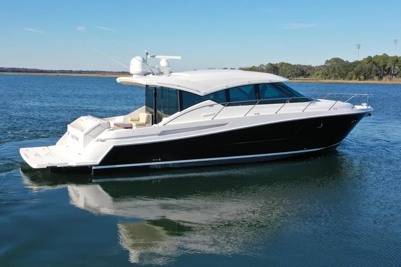 Slide: The Image of 2016 Tiara Yachts 50 Coupe cruising on a calm lake under a clear blue sky. - 2