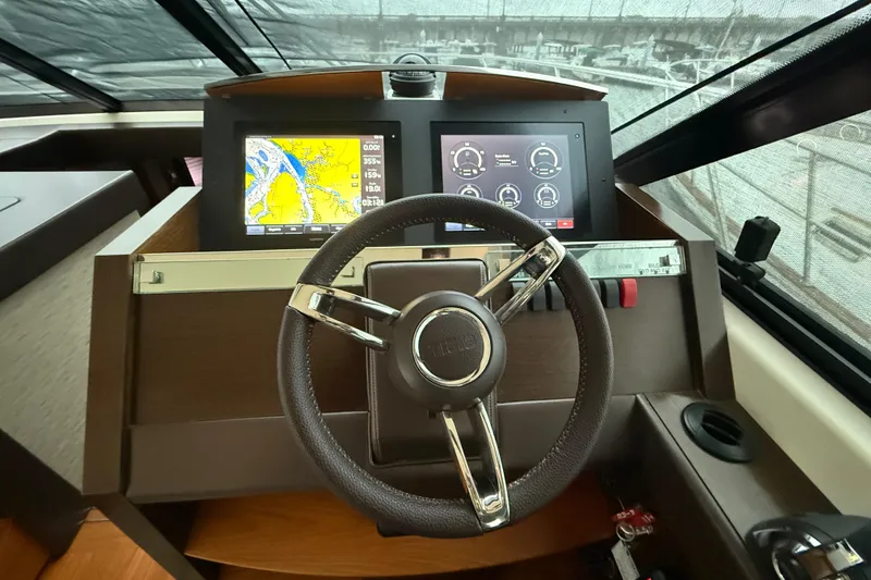 Slide: The Image of Helm of 2016 Tiara Yachts 50 Coupe with navigation screens and steering wheel. - 29