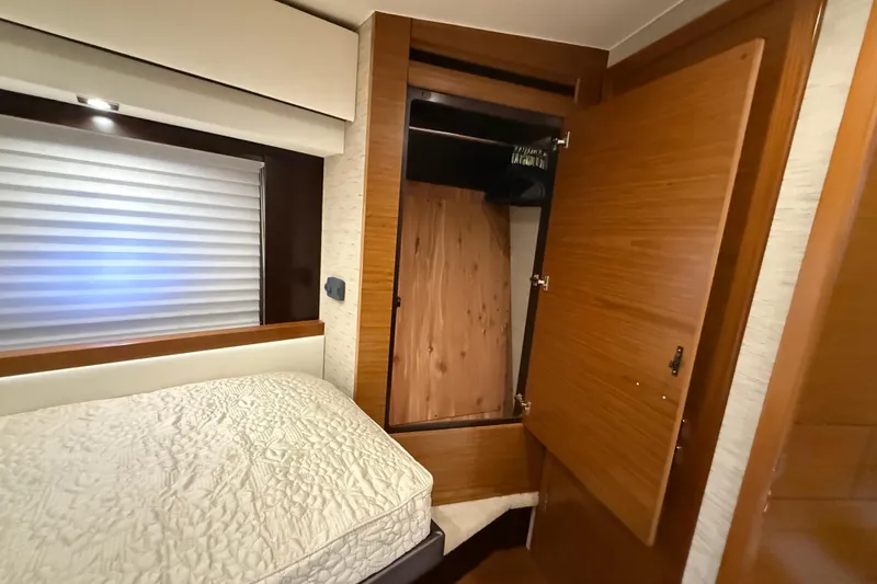 Slide: The Image of 2016 Tiara Yachts 50 Coupe interior with bed and open wooden closet. - 37