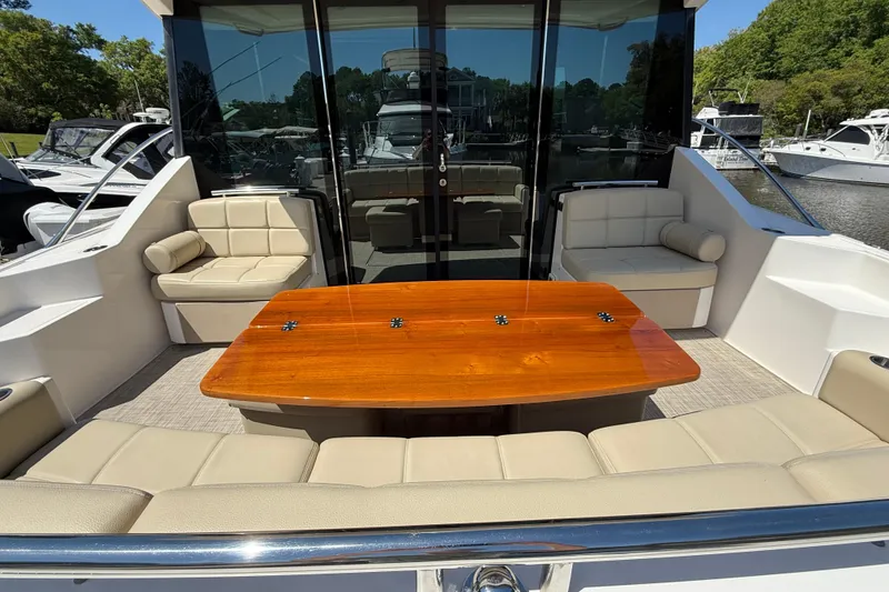 Slide: The Image of 2016 Tiara Yachts 50 Coupe with elegant outdoor seating and polished wooden table. - 53