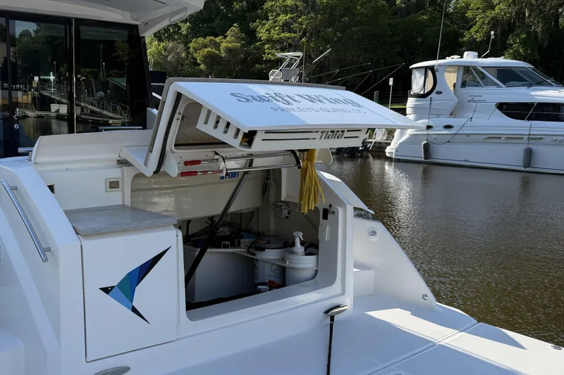 Slide: The Image of 2016 Tiara Yachts 50 Coupe docked, showcasing open storage compartment and sleek design. - 54