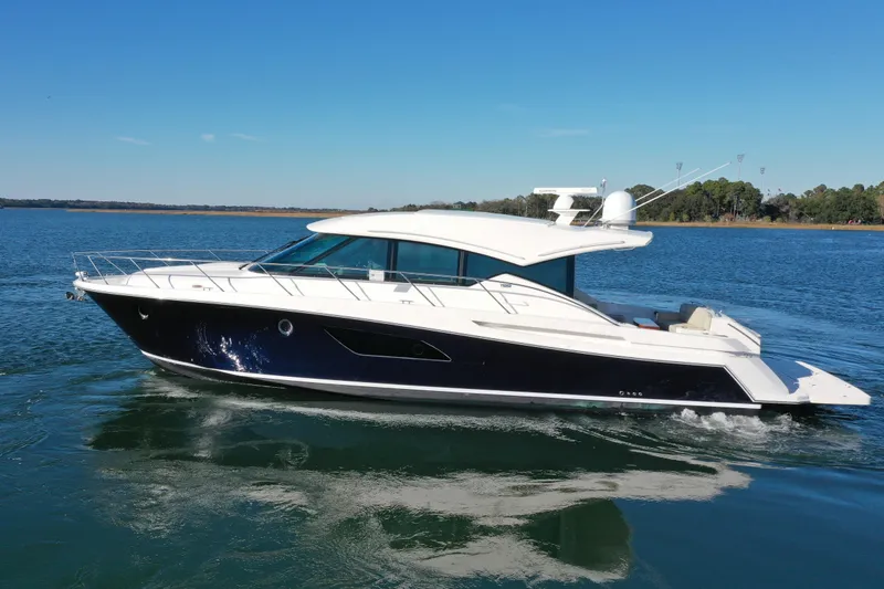 Slide: The Image of 2016 Tiara Yachts 50 Coupe cruising on a serene blue lake under a clear sky. - 6