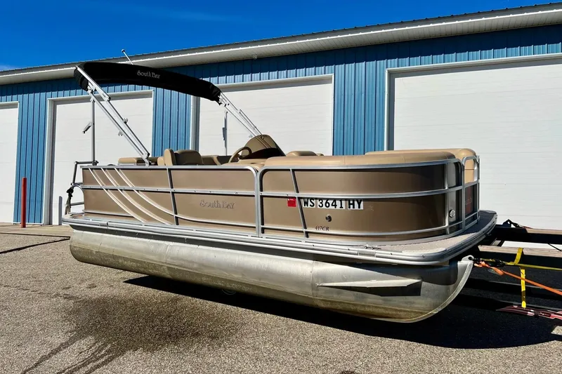 The Image of 2013 South Bay 417 CR pontoon boat parked outside a blue building. - 0