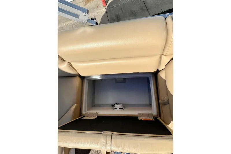 Slide: The Image of 2013 South Bay 417 CR boat interior with open storage compartment and beige seating. - 24