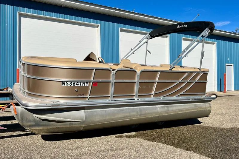 Slide: The Image of 2013 South Bay 417 CR pontoon boat parked outside a blue garage. - 56