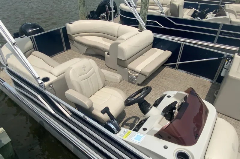 Slide: The Image of 2023 Cypress Cay Seabreeze 232 pontoon boat interior with plush seating and steering console. - 4