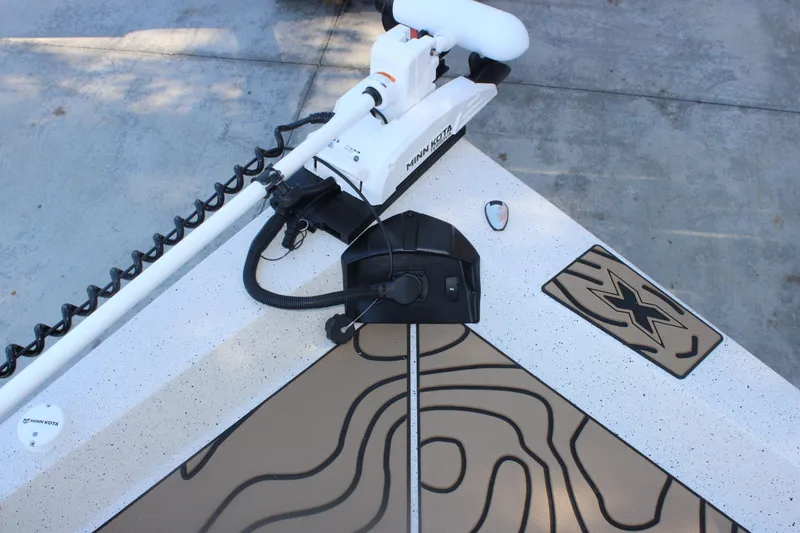 Slide: The Image of 2026 Xpress H20B Bay boat deck with Minn Kota trolling motor and custom mat design. - 20