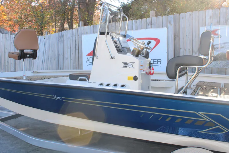 Slide: The Image of 2026 Xpress H20B Bay boat with blue exterior and modern seating, displayed outdoors. - 27