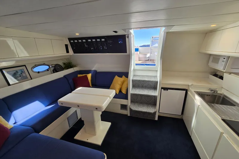 Slide: The Image of Luxurious Giorgi 46 yacht interior, featuring blue seating, kitchenette, and stairs, built in 1993. - 127