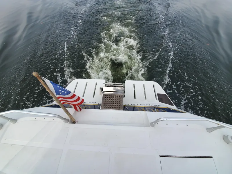Slide: The Image of Rear view of 1993 Giorgi 46 yacht with American flag on water. - 44