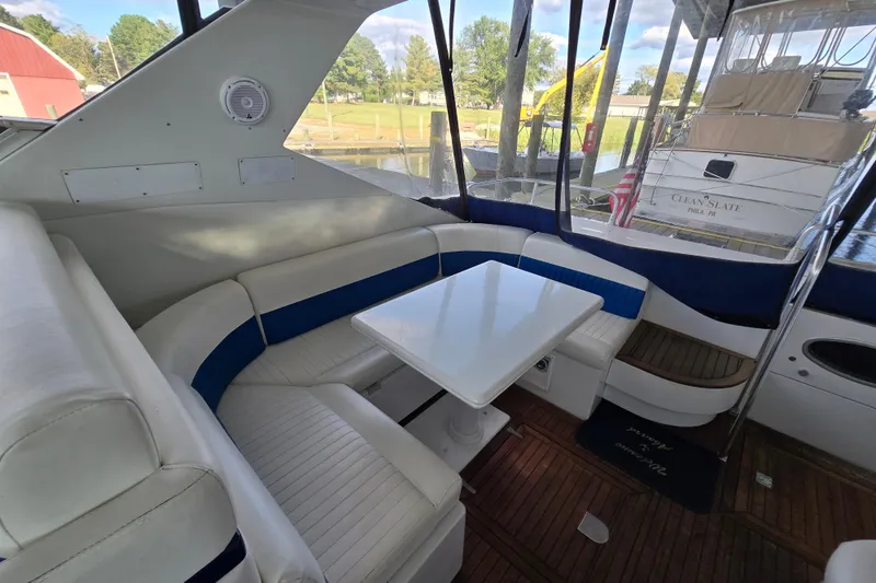 Slide: The Image of Luxurious Giorgi 46 yacht interior with white seating and table, docked near other boats. - 91