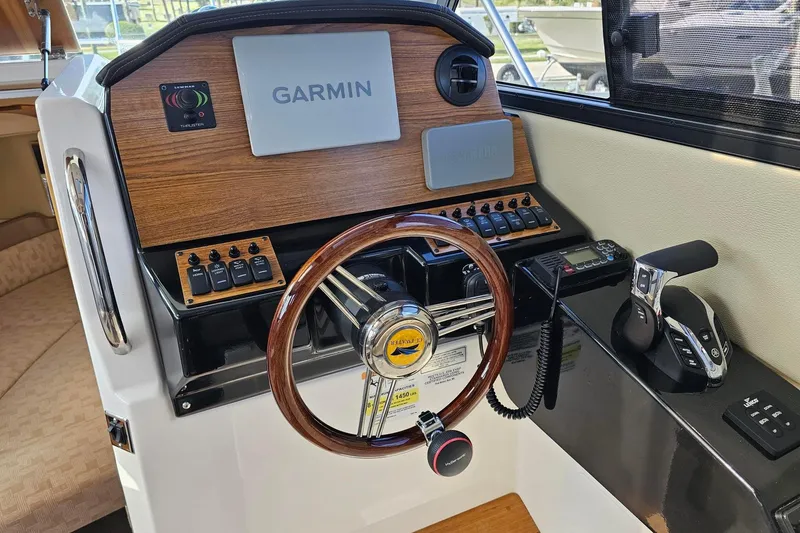 Slide: The Image of 2024 Cutwater C-248 Coupe helm with Garmin navigation and wood-accented steering wheel. - 16