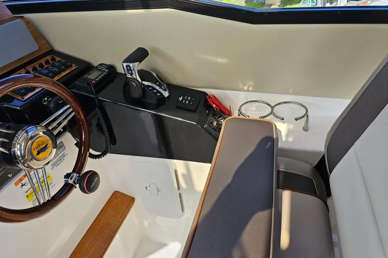 Slide: The Image of 2024 Cutwater C-248 Coupe helm with steering wheel, controls, and seating area. - 18