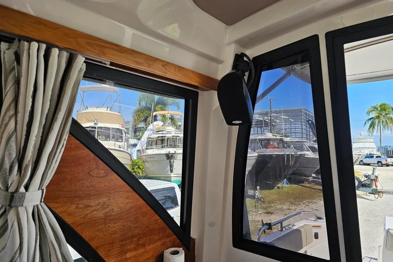 Slide: The Image of Interior view of 2024 Cutwater C-248 Coupe, showcasing windows and docked boats outside. - 26