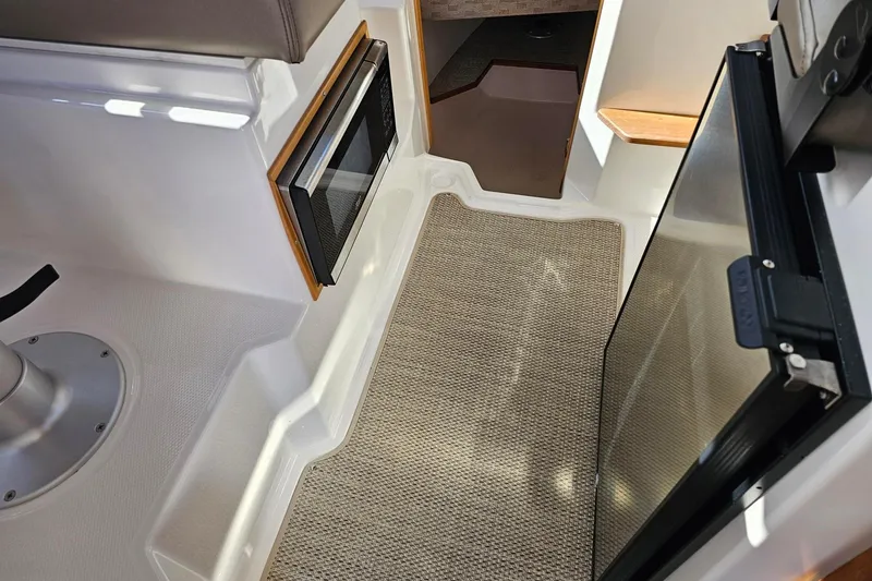 Slide: The Image of 2024 Cutwater C-248 Coupe interior with microwave, carpet, and seating area. - 29