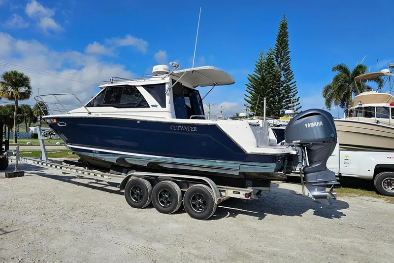 Slide: The Image of 2024 Cutwater C-248 Coupe boat on trailer with Yamaha engine, parked outdoors. - 3