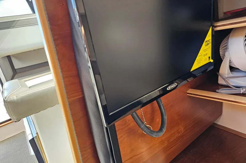 Slide: The Image of 2024 Cutwater C-248 Coupe interior with mounted TV and wooden cabinetry. - 35