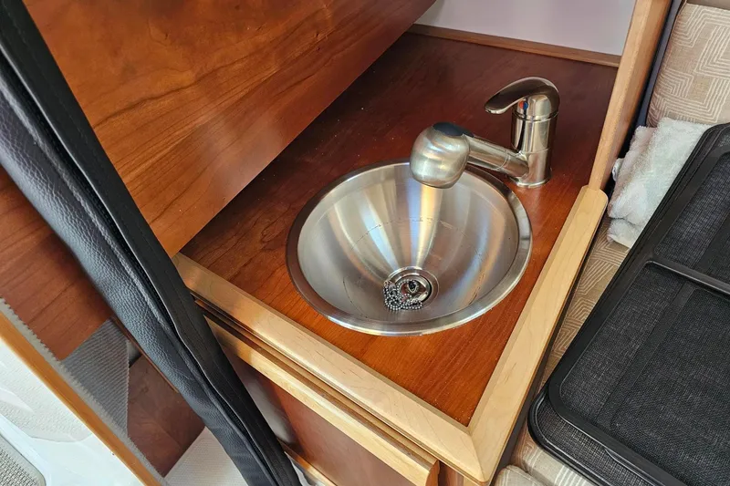 Slide: The Image of 2024 Cutwater C-248 Coupe interior sink with wooden cabinetry and modern faucet. - 36